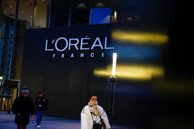 People walk past the logo of French cosmetics group L'Oreal in the north-western Paris suburb of Levallois-Perret, France, January 13, 2025. REUTERS/Gonzalo Fuentes
