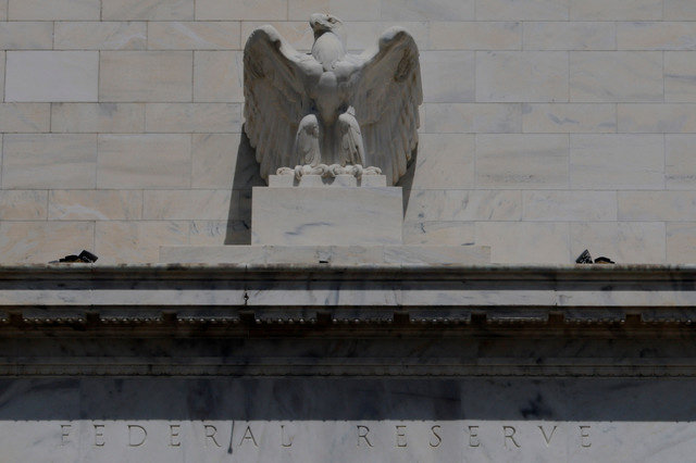 An eagle sits atop the facade of the U.S. Federal Reserve building in Washington, D.C., on August 26, 2025, as President Donald Trump announced the firing of Governor Lisa Cook over alleged mortgage loan improprieties. REUTERS/Brian Snyder