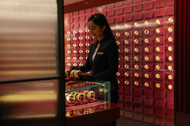 พนักงานร้านแสดงสร้อยข้อมือทองคำเป็นคู่สำหรับงานแต่งงานแบบจีน ระหว่างการเปิดตัวรอบสื่อมวลชนของร้านแฟลกชิปสโตร์ Chow Tai Fook Jewellery Group ในฮ่องกง ประเทศจีน เมื่อวันที่ 11 กุมภาพันธ์ 2026 REUTERS/Tyrone Siu