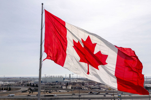 FILE PHOTO: A Canadian flag waves in a plaza near the GM Oshawa Assembly plant in Oshawa, Ontario, Canada on March 14, 2025. REUTERS/Carlos Osorio/File Photo