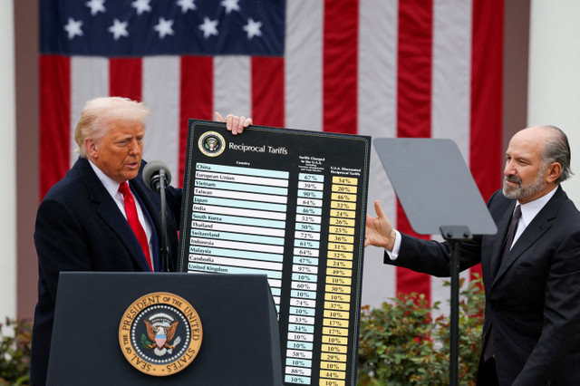 Tổng thống Hoa Kỳ Donald Trump cầm một biểu đồ bên cạnh Bộ trưởng Thương mại Hoa Kỳ Howard Lutnick khi ông phát biểu về thuế quan tại Vườn Hồng ở Nhà Trắng, Washington, D.C., Hoa Kỳ, vào ngày 2 tháng 4 năm 2025. REUTERS/Carlos Barria/File Photo