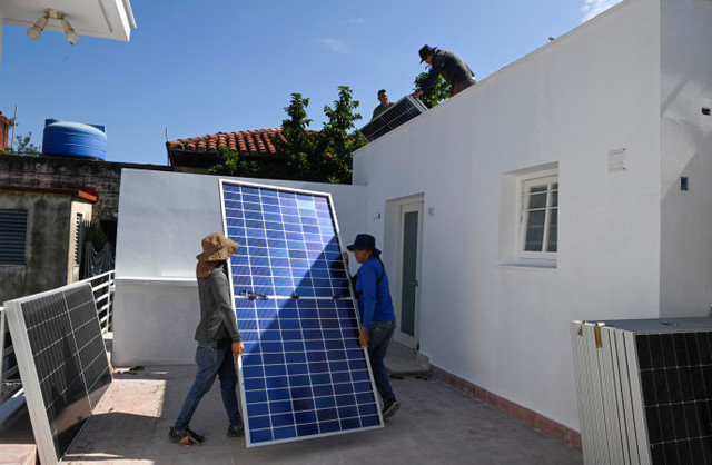 Trabajadores instalan un panel solar en el techo de una empresa privada mientras los cubanos enfrentan una crisis energética agravada por la escasez de combustible, La Habana, Cuba, 18 de febrero de 2026. REUTERS/Norlys Perez