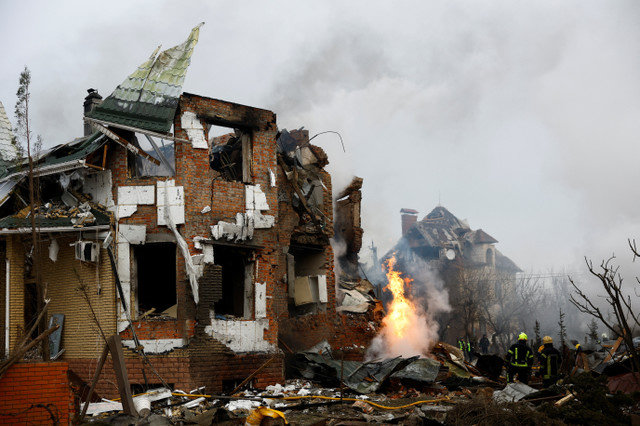 2026年2月22日、ロシアによるウクライナ侵攻の中、ウクライナのキーウで、ロシアのドローンおよびミサイル攻撃により損傷した住宅ビルの現場で作業する消防士。REUTERS/Valentyn Ogirenko