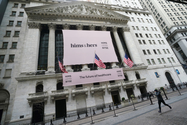 A Bolsa de Valores de Nova York com um banner da Hims & Hers Health, Inc é vista enquanto uma pessoa passa correndo no bairro de Manhattan, na cidade de Nova York, Nova York, EUA, em 21 de janeiro de 2021. REUTERS/Carlo Allegri