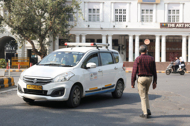 Um homem conduz um táxi da Bharat Taxi numa estrada em Nova Deli, Índia, a 24 de fevereiro de 2026. REUTERS/Bhawika Chhabra