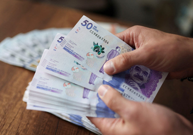 Um funcionário conta pesos colombianos em uma casa de câmbio em Bogotá, Colômbia, 11 de julho de 2022. REUTERS/Luisa Gonzalez