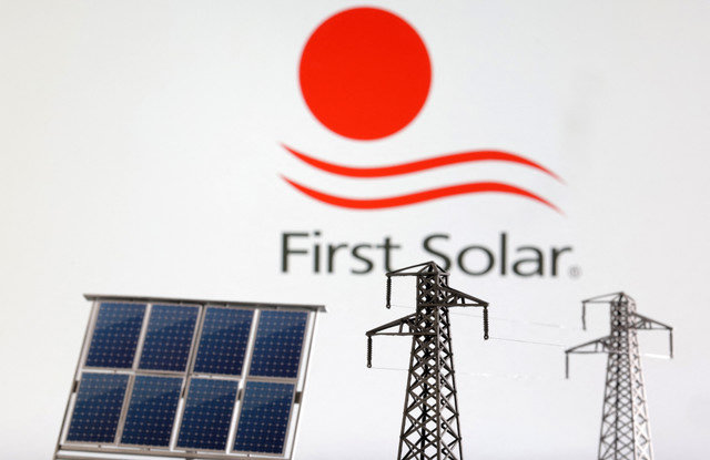 หุ่นจำลองแผงโซลาร์เซลล์และเสาไฟฟ้าปรากฏอยู่ด้านหน้าโลโก้ First Solar ในภาพประกอบที่ถ่ายเมื่อวันที่ 17 มกราคม 2023 REUTERS/Dado Ruvic/Illustration