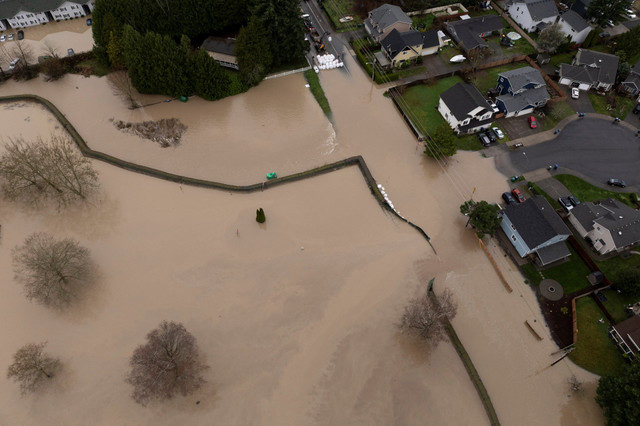 An aerial drone perspective captures the breach of a temporary flood levee along the White River in Washington state following intense atmospheric river storms. REUTERS/David Ryder