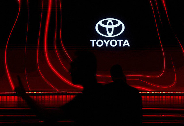 A pedestrian passes the Toyota corporate logo at a promotional event in Mumbai, India, captured in January 2026. REUTERS/Francis Mascarenhas/File Photo