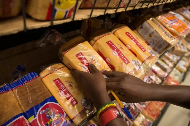 A supermarket employee in Nairobi, Kenya, arranges loaves of bread in this file photo from May 2017. REUTERS/Baz Ratner/File Photo