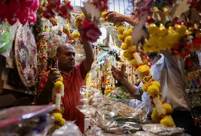 インド、デリーの旧市街にある市場で装飾材料の店を整理する業者(2025年10月17日撮影) REUTERS/Bhawika Chhabra/File Photo
