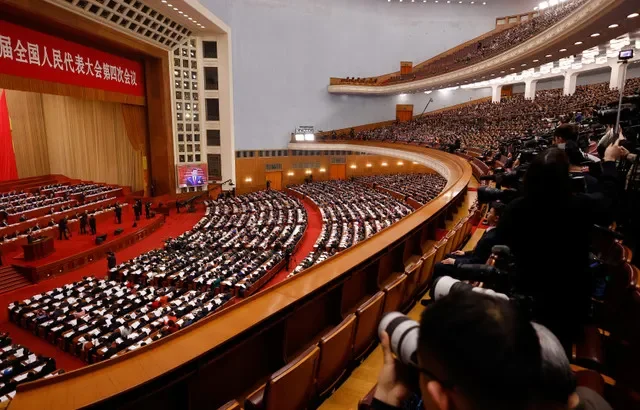 2026年3月5日,中国北京,记者和代表出席在人民大会堂举行的全国人民代表大会开幕式,屏幕上播放着中国国家主席习近平的画面。 REUTERS/Maxim Shemetov