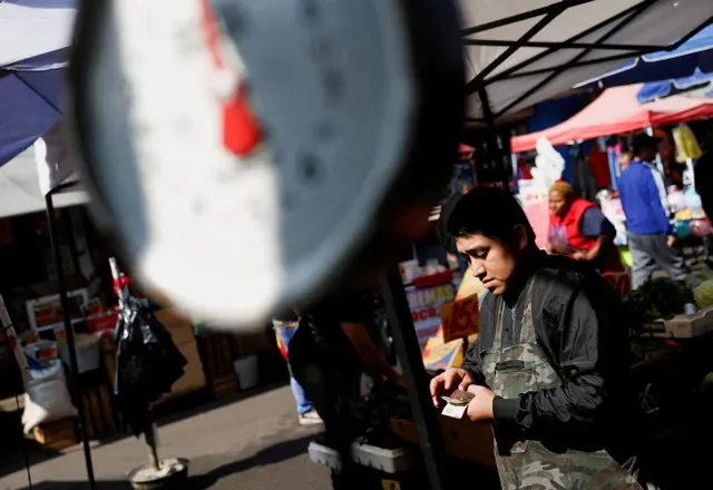A merchant handles currency at a local market in Monterrey, Mexico, captured in January 2026. REUTERS/Daniel Becerril