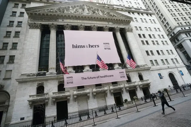 ภาพบรรยากาศตลาดหลักทรัพย์นิวยอร์กพร้อมป้ายแบนเนอร์ของ Hims & Hers Health, Inc. ขณะที่มีคนวิ่งผ่านในย่านแมนแฮตตัน นครนิวยอร์ก รัฐนิวยอร์ก สหรัฐอเมริกา เมื่อวันที่ 21 มกราคม 2021 โดย REUTERS/Carlo Allegri