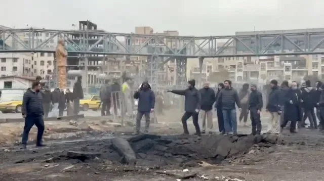 أشخاص يقفون في منطقة متضررة في الشارع عقب غارة أُبلغ عنها وسط الصراع الأمريكي الإسرائيلي مع إيران، في طهران، إيران، 10 مارس 2026. جمعية الهلال الأحمر الإيراني عبر رويترز
