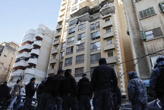 以色列袭击后,救援人员站在黎巴嫩贝鲁特市中心受损的公寓楼旁。REUTERS/Emilie Madi