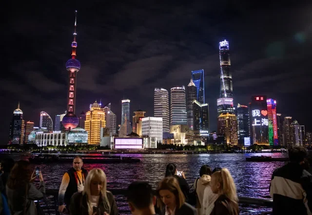 Pedestrians walk along the Bund with the Lujiazui financial district skyscrapers visible across the Huangpu River in Shanghai, China, on November 4, 2025. REUTERS/Maxim Shemetov
