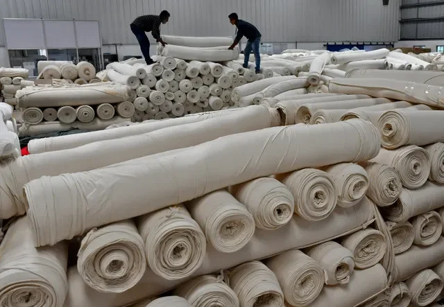 Công nhân xếp các cuộn vải cotton tại một nhà máy dệt của Texport Industries ở thị trấn Hindupur, bang Andhra Pradesh, Ấn Độ. Ảnh chụp ngày 9/2/2022. REUTERS/Samuel Rajkumar/File Photo
