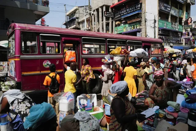 Các tiểu thương bán hàng dọc theo một con phố nhộn nhịp tại chợ Makola ở Accra, Ghana, ngày 6 tháng 12 năm 2025. REUTERS/Francis Kokoroko