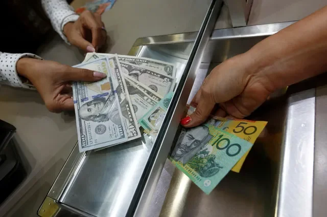 2016年6月7日、オーストラリアのシドニーにある両替所で撮影されたオーストラリアドルと米ドルの紙幣。REUTERS/Jason Reed