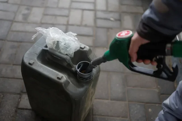 A petrol station employee fills jerry cans in Kherson, Ukraine, following the Russian retreat in late 2022. REUTERS/Valentyn Ogirenko