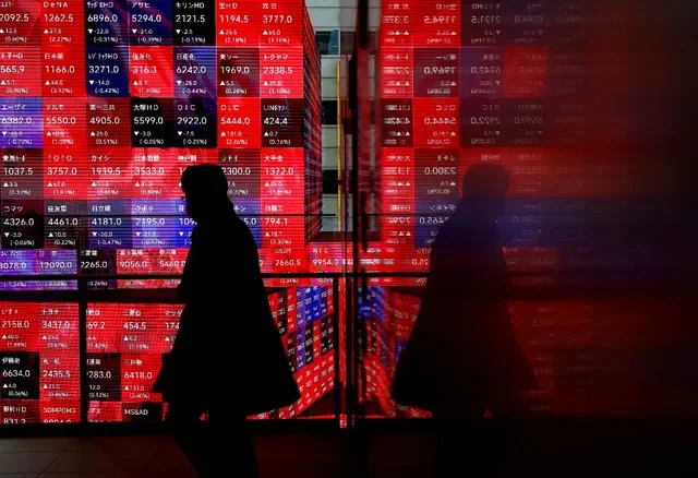资料图片:2024年2月19日,一名访客走过日本东京一座大楼内的日经股票价格行情板。路透社/Issei Kato/File Photo