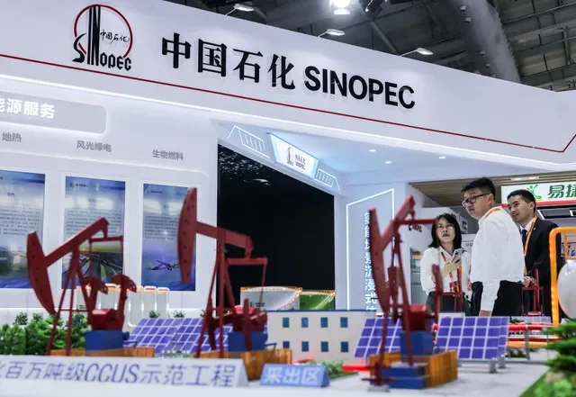 Attendees observe miniature oil pump jacks at the China Petroleum & Chemical Corporation exhibition space during the China International Fair for Trade in Services in Beijing, dated September 11, 2025. REUTERS/Maxim Shemetov