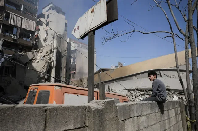 2026年3月18日,黎巴嫩贝鲁特,一名男孩坐在以色列袭击现场废墟附近的墙上。REUTERS/Khalil Ashawi