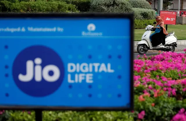2018年7月5日,印度艾哈迈达巴德,一名妇女骑着踏板车经过信实工业旗下 Jio 电信部门的广告。路透社/Amit Dave/文件照片