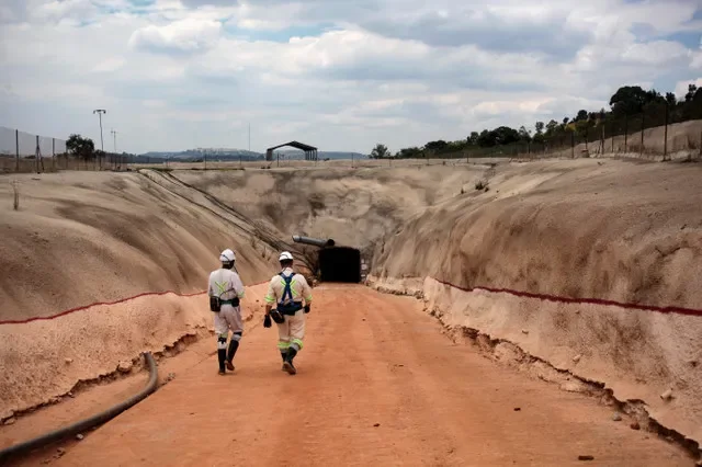 Trabajadores mineros caminan hacia una entrada en Qala Swallows, la primera nueva mina de oro subterránea de Sudáfrica en 15 años, en Roodepoort, al oeste de Johannesburgo, Sudáfrica, el 18 de febrero de 2026. REUTERS/Oupa Nkosi
