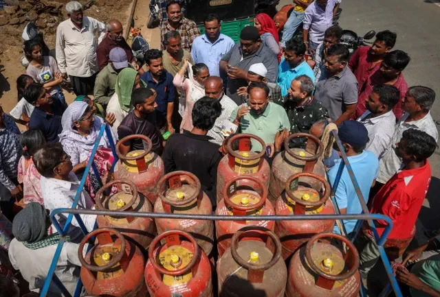 Citizens gather around a delivery vehicle to secure LPG cylinders in Ahmedabad as supply chains face disruptions. REUTERS/Amit Dave