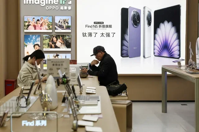 Clientes compran teléfonos inteligentes en el centro comercial de electrónica BuyNow en Shanghái, China, el 14 de abril de 2025. REUTERS/Go Nakamura