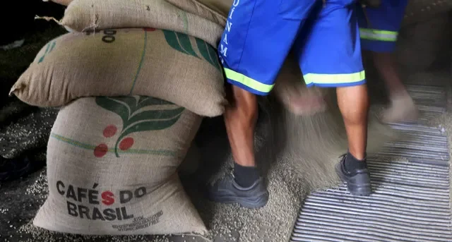Workers in Santos, Brazil, unload 60-kg jute bags of coffee beans intended for export at a local warehouse. REUTERS/Paulo Whitaker/File Photo