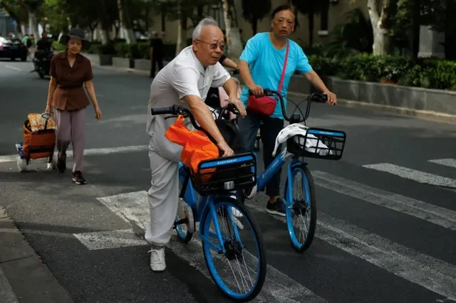 Idosos andam de bicicleta em um serviço de compartilhamento de bicicletas em uma rua em Xangai, China, 28 de setembro de 2024. REUTERS/Tingshu Wang