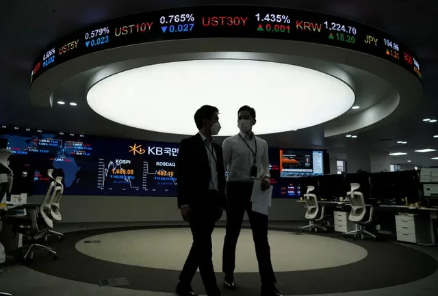 Operadores de câmbio passam por um painel eletrônico que mostra o Korea Composite Stock Price Index (KOSPI) em uma sala de negociações de um banco em Seul, Coreia do Sul, em 13 de março de 2020. REUTERS/Kim Hong-Ji/Foto de Arquivo