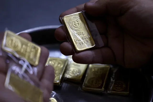 A jeweler in Cairo, Egypt, displays a gold bar as local demand for precious metals surges among buyers seeking financial security during a period of market instability in March 2026. REUTERS/Mohamed Abd El Ghany