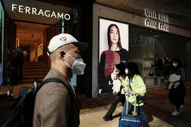 2023年2月15日、中国・香港の尖沙咀(チムサーチョイ)地区で高級ブランド店の前を歩く買い物客。REUTERS/Lam Yik