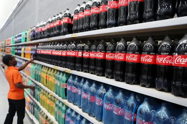 Một công nhân đứng cạnh kệ hàng bày bán các chai nước giải khát Coca-Cola tại cửa hàng Makro Store Riversands thuộc nhà bán lẻ Massmart ở Midrand, Nam Phi. Ảnh chụp ngày 28/08/2019. REUTERS/Siphiwe Sibeko
