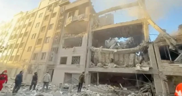 أشخاص يقفون بالقرب من مبانٍ متضررة وسط الصراع الأمريكي الإسرائيلي مع إيران في طهران، إيران، في هذه الصورة الثابتة المأخوذة من فيديو وزعته جمعية الهلال الأحمر الإيراني في 1 أبريل 2026. رويترز