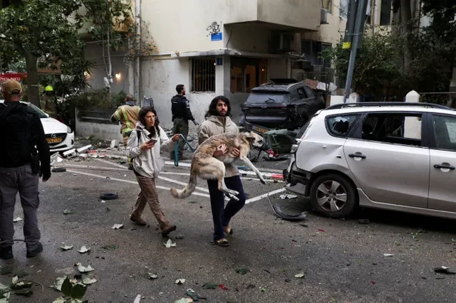 Un hombre lleva a un perro a un refugio mientras suenan las sirenas después de que Irán lanzara misiles hacia Israel, en medio del conflicto de EE. UU. e Israel con Irán, en Tel Aviv, Israel, el 1 de abril de 2026. REUTERS/Ronen Zvulun