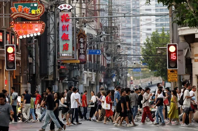 Pedestrians walk through a restaurant-filled alleyway at a commercial district in Shanghai, China, captured on September 28, 2024. REUTERS/Tingshu Wang
