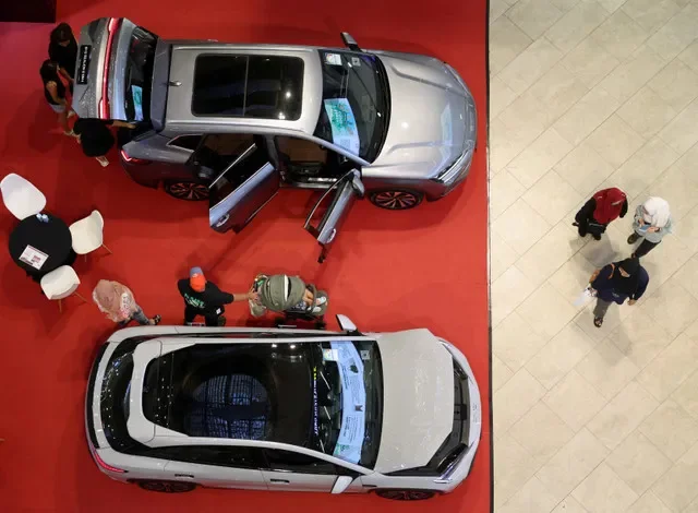 FOTO DE ARCHIVO: Personas observando vehículos eléctricos de BYD en una exhibición en un centro comercial en Singapur, 30 de marzo de 2026. REUTERS/Edgar Su/Foto de archivo