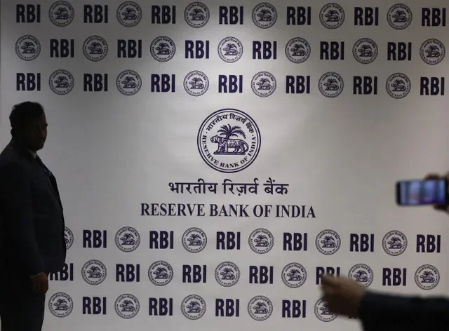 ชายยืนอยู่หน้าโลโก้ธนาคารกลางอินเดีย (RBI) ภายในสำนักงานใหญ่ในเมืองมุมไบ ประเทศอินเดีย เมื่อวันที่ 6 กุมภาพันธ์ 2026 ภาพโดย REUTERS/Francis Mascarenhas/File Photo