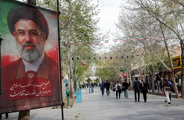 أشخاص يسيرون بجانب ملصقات للمرشد الأعلى الجديد لإيران، مجتبى خامنئي، في شارع بأصفهان، إيران، 24 مارس 2026. رويترز/علاء المرجاني