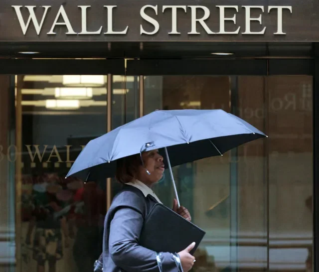 FOTO DE ARCHIVO: Una mujer camina bajo la lluvia en Wall Street, Nueva York, el 16 de agosto de 2011. REUTERS/Brendan McDermid/Foto de archivo