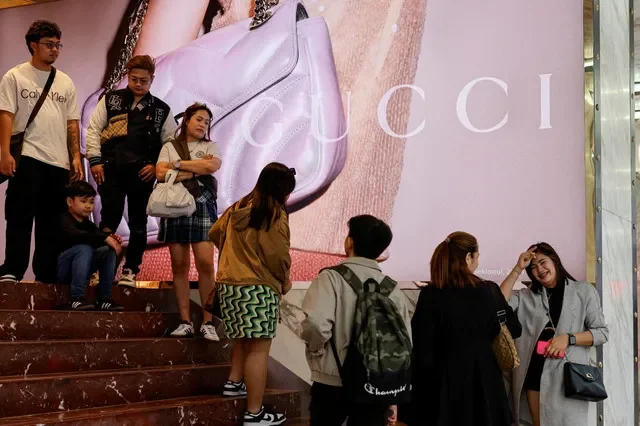 Shoppers wait in line at a Gucci boutique located in the Tsim Sha Tsui shopping district of Hong Kong, China, in late 2023. REUTERS/Tyrone Siu/File Photo