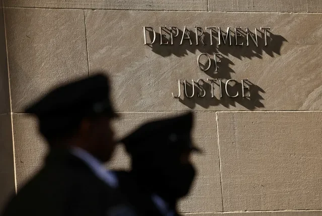 Security personnel maintain a presence outside the U.S. Department of Justice headquarters in Washington, D.C., during April 2026. REUTERS/Kevin Lamarque