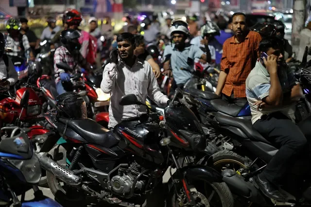 Người đi xe máy chờ đợi bên ngoài sau khi một trạm xăng đóng cửa vào buổi tối tại Dhaka, Bangladesh ngày 6 tháng 4 năm 2026. REUTERS/Mohammad Ponir Hossain