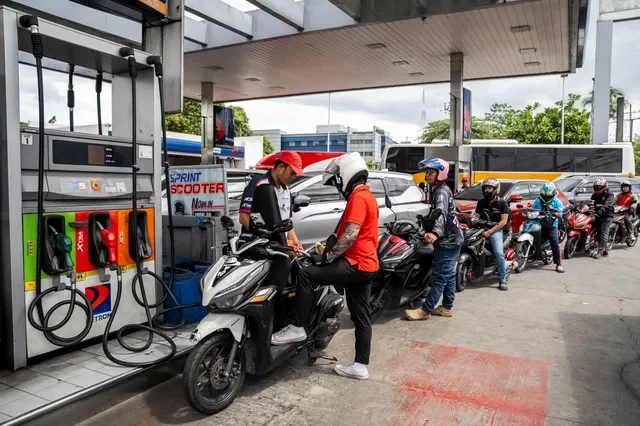 Một nhân viên đổ xăng cho xe máy trong khi các tài xế xếp hàng tại một trạm xăng khi giá dầu dự kiến sẽ tăng trong bối cảnh xung đột giữa Mỹ-Israel với Iran, tại thành phố Quezon, Metro Manila, Philippines, ngày 9 tháng 3 năm 2026. REUTERS/Lisa Marie David