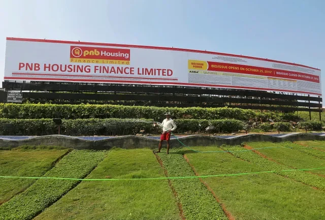 FOTO DE ARCHIVO: Un jardinero riega el césped frente a un anuncio de la oferta pública inicial (IPO) de PNB Housing Finance Ltd. en Mumbai, India, el 25 de octubre de 2016. REUTERS/Shailesh Andrade/Foto de archivo